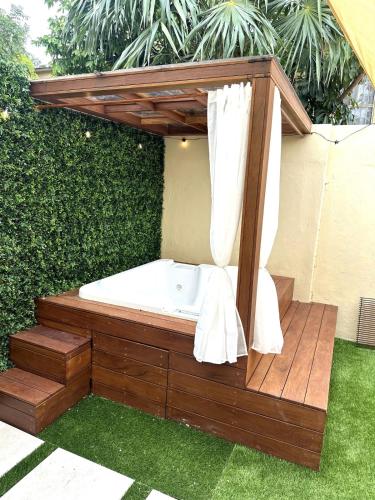 a jacuzzi tub sitting on a deck in a garden at Privada cerca de playa con Jacuzzi, BBQ y Terraza in Cancún