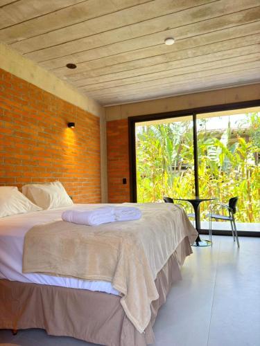 a bedroom with a bed and a brick wall at Flat Camburi in Camburi