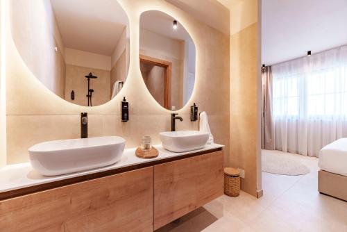 ein Badezimmer mit zwei Waschbecken und einem großen Spiegel in der Unterkunft Vila VitaMaris in Okrug Donji