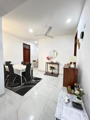 a white living room with a table and chairs at Zanzibar Cozy Home in Zanzibar City