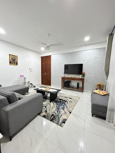 a living room with a couch and a tv at Zanzibar Cozy Home in Zanzibar City
