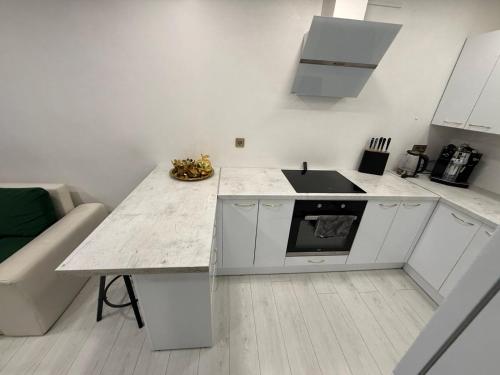 a kitchen with a counter with a sink and a stove at Welcome to Dovas Home in Anykščiai