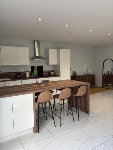 a kitchen with a wooden table and stools at Maison neuve 2 chambres entre Dordogne et Corrèze in Terrasson-Lavilledieu