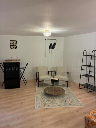 uma sala de estar com uma mesa e cadeiras de vidro em Studio Cozy avec terrasse idéalement situé em Angers