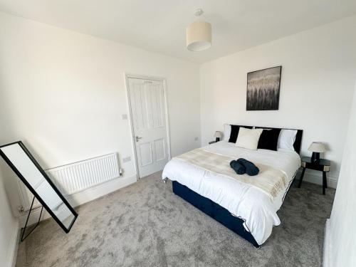 une chambre blanche avec un grand lit et un miroir dans l'établissement Modern 3-Bed House Near Attractions & Beach, à Blackpool