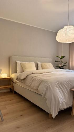 a bedroom with a large bed with white sheets and pillows at Hygge & Schwarzwald - 2 Zimmer Wohnung in Bad Krozingen in Bad Krozingen