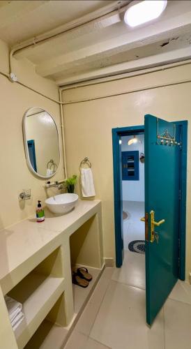 a bathroom with a sink and a blue door at Casa Blanca - calm space for soul revival in Ādam