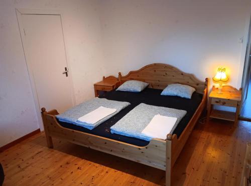 two twin beds in a room with a lamp at House in the middle of forests and lakes in Svartträsk