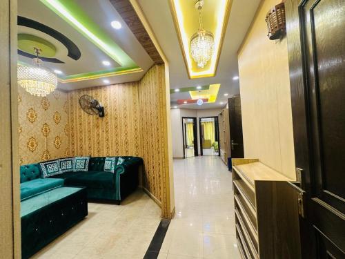 un pasillo con un sofá verde en una habitación en Grand apartments, en Lahore