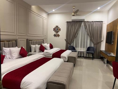 ein Hotelzimmer mit zwei Betten und einer Couch in der Unterkunft Holiday One Hotel & Suites in Karatschi