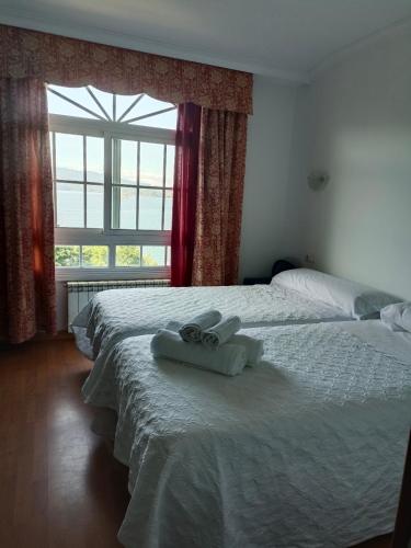 a bedroom with two beds with towels on them at CHOCOLATE y MENTA REDONDELA in Redondela