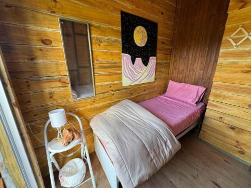 a small room with a bed in a cabin at Serendipia Hostel Punta Rubia in La Pedrera