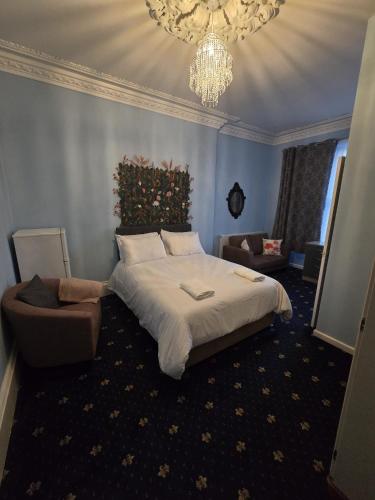 a bedroom with a large bed and a chandelier at Maqs Bistro in Egremont