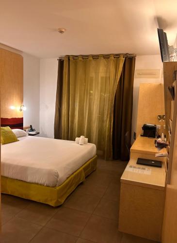 a hotel room with a bed and a desk at Logis Hôtel La Fauceille in Perpignan