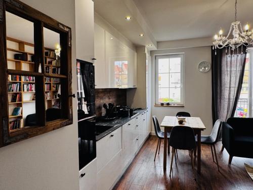 een keuken met een tafel en een eetkamer bij Apartament Villa Park in Ełk