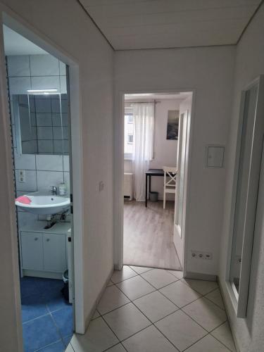 a white bathroom with a sink and a mirror at Ferienwohnung Biberach an der Riß in Biberach an der Riß