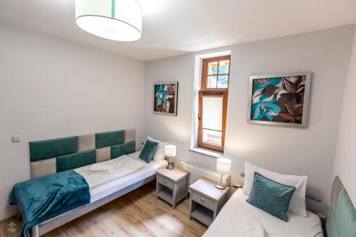 a bedroom with a bed and a couch and a window at Apartament 41 w Willi Józefina, parking w cenie! MBnoclegi in Szklarska Poręba