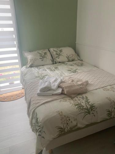 ein Bett in einem Schlafzimmer mit einer Decke drauf in der Unterkunft Studio indépendant Sdb privée 