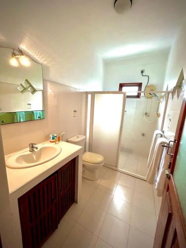 ein Badezimmer mit Waschbecken, Toilette und Dusche in der Unterkunft French Residence Tangalle in Tangalle