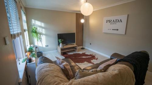a living room with a couch and a tv at Cosy Glasgow Barrowlands stay-spacious & free parking in Glasgow