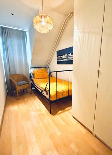 a small bedroom with a bed and a chair at Entire home, 3 bedrooms garden Strijp within ring in Eindhoven
