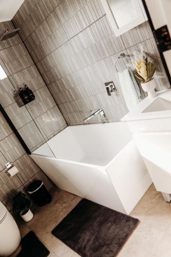 a bathroom with a white tub and a sink at Modern Oberon Retreat Close to Lakes & Forests in Oberon