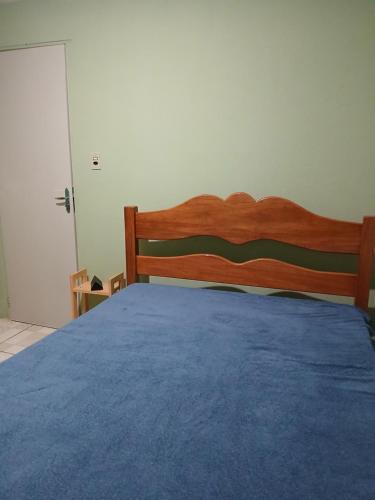 - une chambre avec un lit en bois et une couverture bleue dans l'établissement Casa ou Quartos, à Surubim