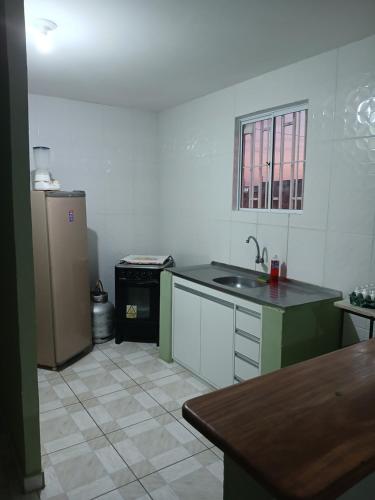 une cuisine avec un évier et un réfrigérateur dans l'établissement Casa ou Quartos, à Surubim