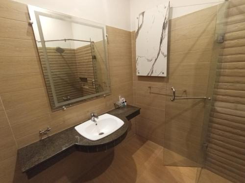 ein Badezimmer mit Waschbecken und Dusche in der Unterkunft Holiday One Hotel & Suites in Karatschi