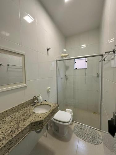 a bathroom with a toilet and a sink and a shower at Apartamento no centro próximo a Jk in Palmas