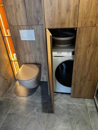 a small bathroom with a toilet and a microwave at Rabczański Taras z jacuzzi i otwieranym dachem in Rabka-Zdrój