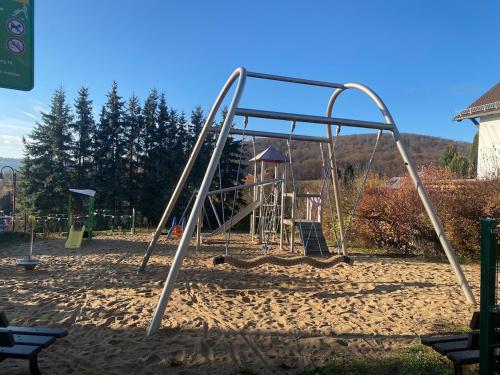 einen Spielplatz mit einer Schaukel im Sand in der Unterkunft Ferienwohnung Am Steinberg in Nauendorf