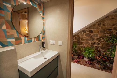 a bathroom with a sink and a mirror and plants at Casa Carmela Baiona in Baiona