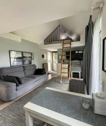 a living room with a couch and a loft bed at Mini House With Sandy Beach And Sauna in Olofstorp