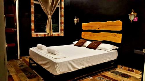 une chambre avec un lit avec des draps blancs et une fenêtre dans l'établissement Goan Cozy 2 Bedroom Abode, à Calangute