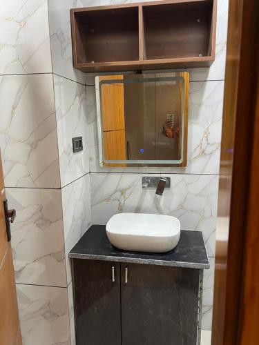 a bathroom with a sink and a mirror on a counter at Singhal Residency in Greater Noida