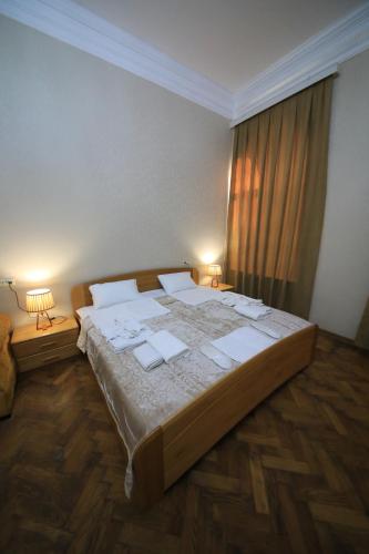 una cama grande en una habitación con ventana en Gallery inn, en Kutaisi