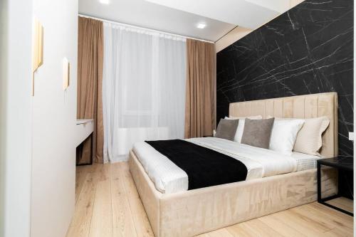 a bedroom with a large bed with a black wall at Brand New Flat Near Cafes and Shops I Full Ameneties in Floreşti