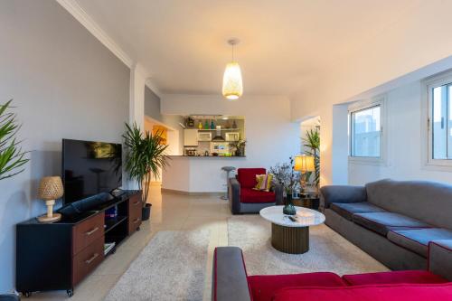ein Wohnzimmer mit Sofa und Fernseher in der Unterkunft 18th floor Nile View with Jacuzzi in Zamalek in Kairo