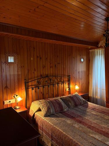a bedroom with a bed with a wooden wall at Villa Tojo in Touro
