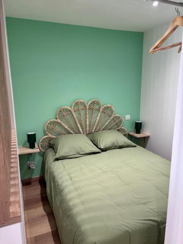 ein Schlafzimmer mit einem großen Bett mit einer blauen Wand in der Unterkunft Le Cocon Vert in Cognac
