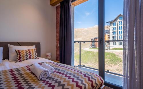 a bedroom with a bed and a large window at New Gudauri Apartments in Twins in Gudauri