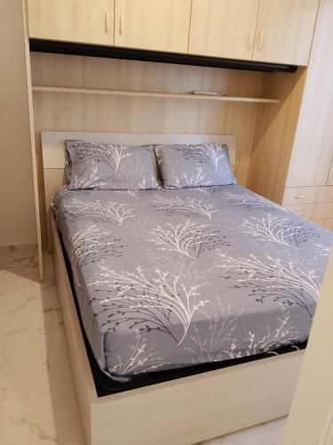 een bed met een paarse sprei en kussens bij Il sorriso romagnolo in Misano Adriatico