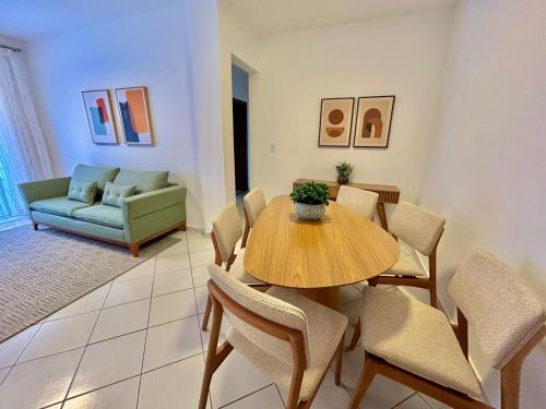 una sala da pranzo con tavolo, sedie e divano di Apê charmoso a 2km do Centro - 4km do Pq Aquático ad Águas de Lindóia