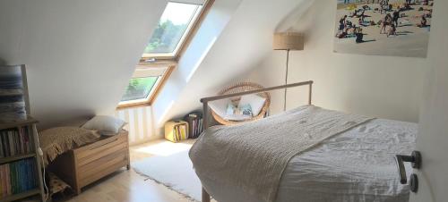 a attic bedroom with a bed and a mirror at Maison moderne 150 m2 à 15mn du centre ville in Aigné
