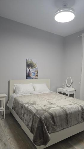 a white bedroom with a bed and a lamp at KYANA Luxury KVA II in Kavála