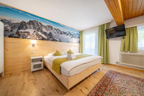 a bedroom with a bed and a flat screen tv at Pension Hofweyer in Ramsau am Dachstein