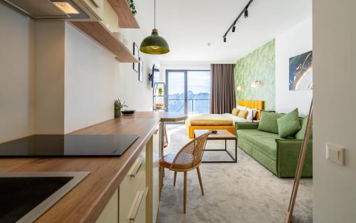 古多里New Gudauri Apartments in Twins的厨房以及带绿色沙发的客厅。