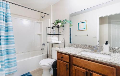a bathroom with a sink and a toilet and a mirror at Cozy 4 BR Abode in Jacksonville