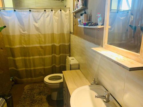 ein kleines Badezimmer mit Toilette und Waschbecken in der Unterkunft Casa en La Barra para 5 in Punta del Este